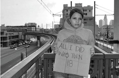 Youth holding sign: All I did was turn 18